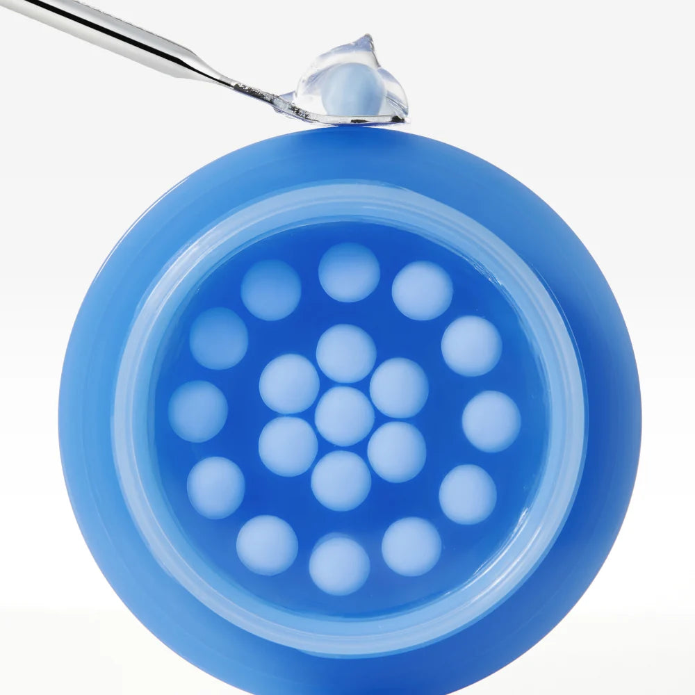 Geöffneter Tiegel der Medicube Hyaluronic Moisturizing Capsule Cream mit blauen Kapseln und transparentem Gel
