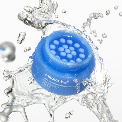 Medicube Hyaluronic Moisturizing Capsule Cream mit sichtbaren Kapseln in einem transparenten Wassersplash