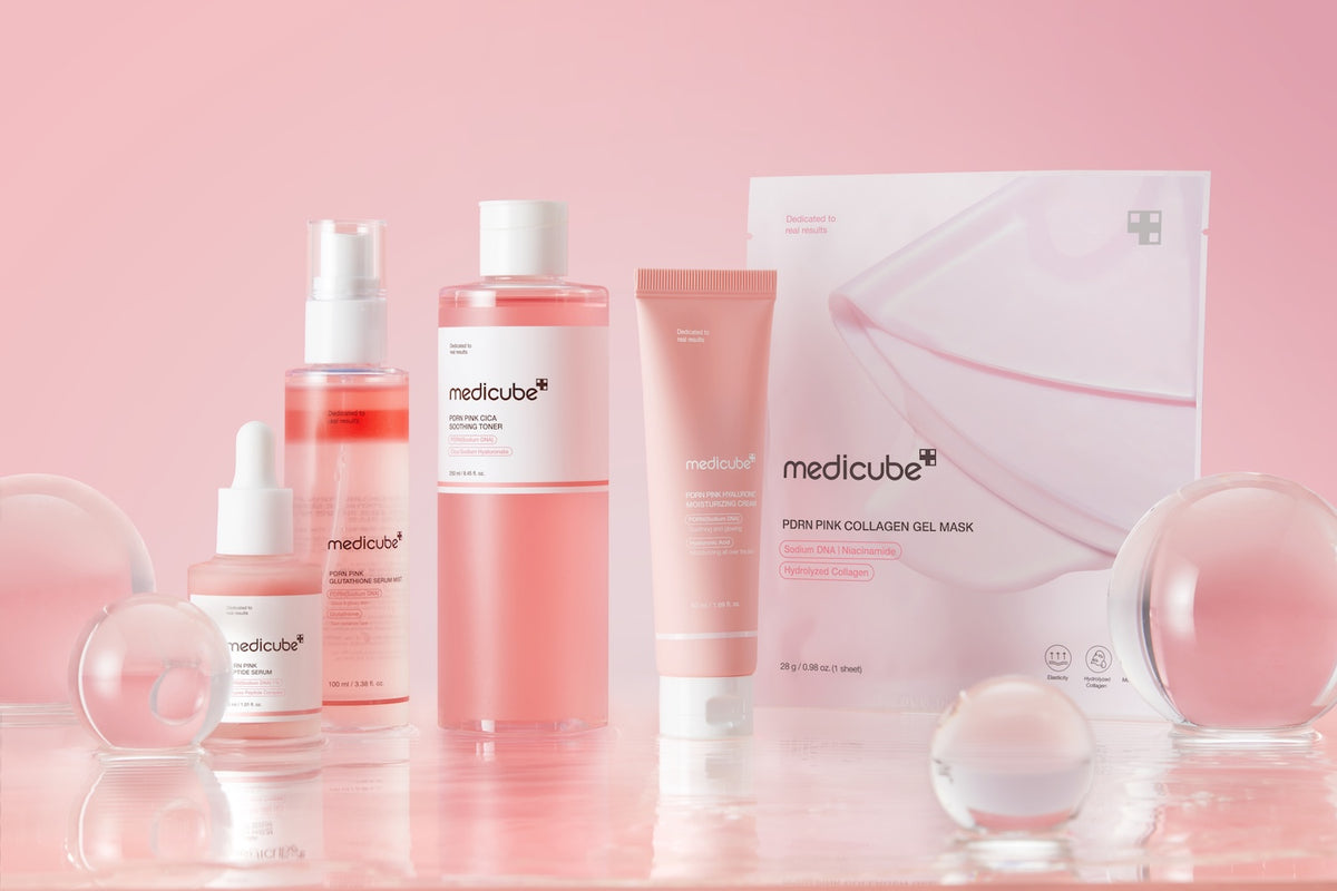 Medicube PDRN Pink Pflegeserie mit Serum, Toner, Feuchtigkeitscreme und Collagen Gel Mask vor rosa Hintergrund