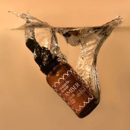 Nuggela & Sulé Amber Haarölflasche in einem transparenten Wassersplash